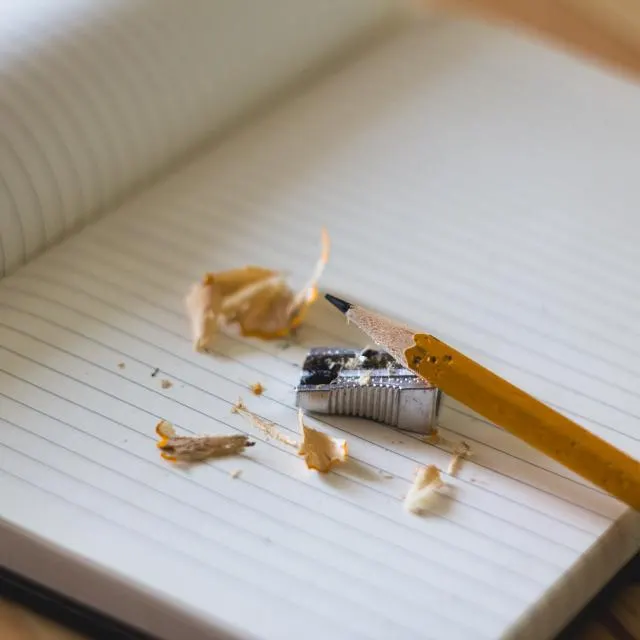 Caderno aberto com lápis apontado